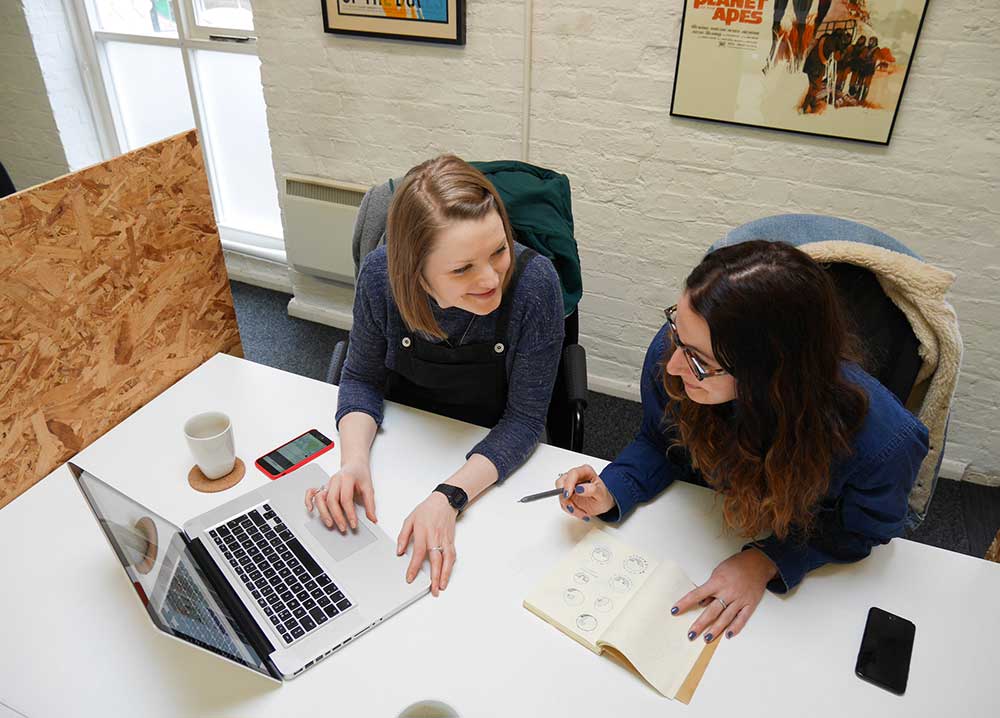 Sally & Kim of Off Grid sharing their ideas around a table